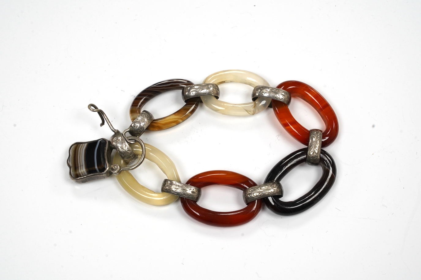 A white metal, carnelian and banded agate set loop link bracelet, 14cm. Condition - poor